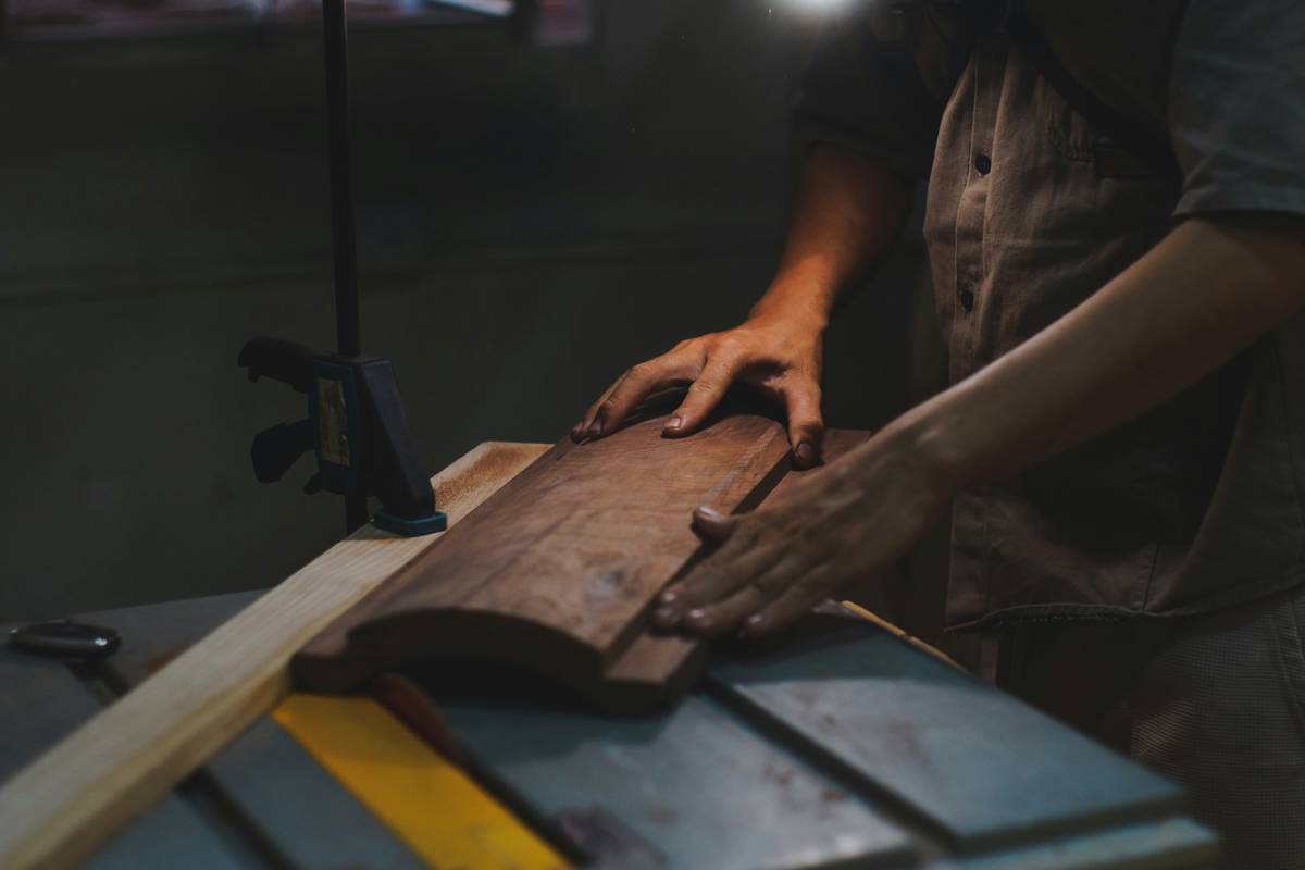 scroll saw cutting wood on a pine board with fine dust accumulation and steady hand guidance