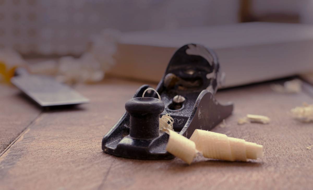 Close-up of hands using a scroll saw with precise control while cutting intricate wood pattern; demonstrates scroll saw techniques woodworking