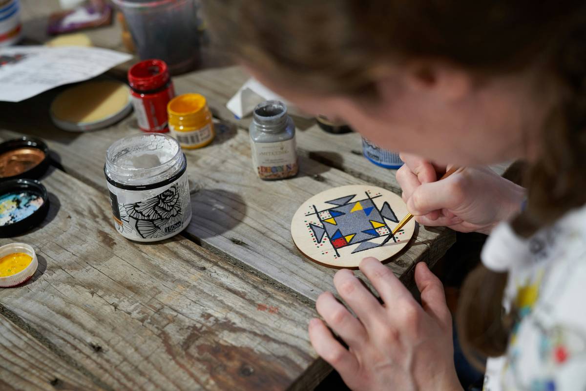 Wooden heart-shaped scroll saw beginner projects on a workbench with safety goggles and extra blades nearby