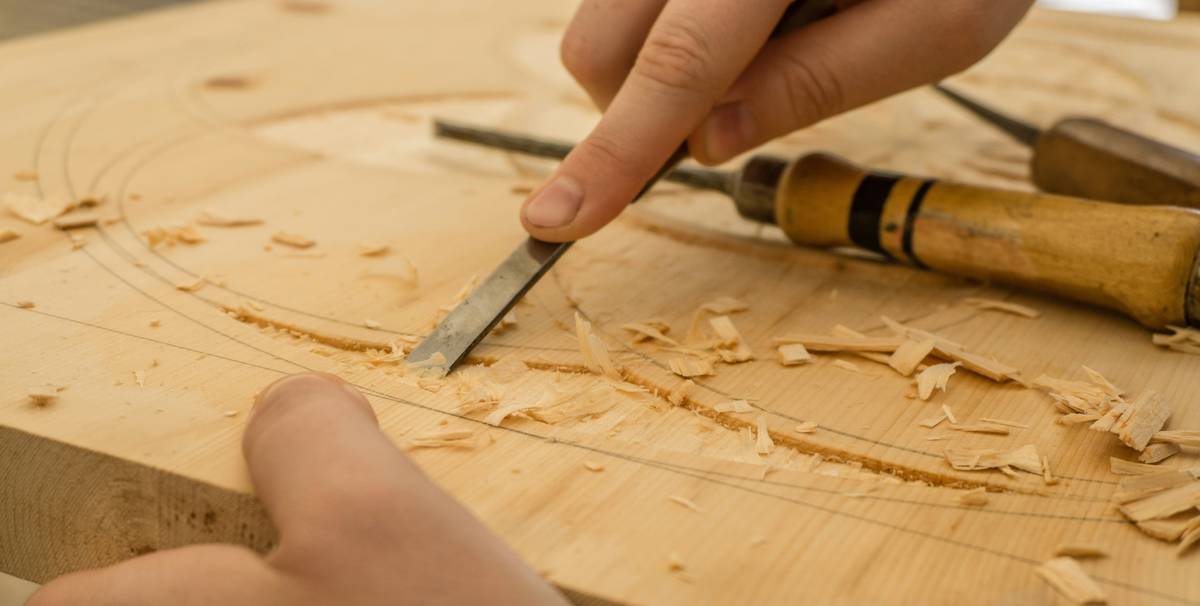 craftsman tools scroll saw cutting intricate wooden design on workbench